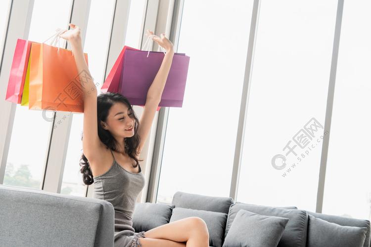快乐的女士拿着购物袋喜欢在百货商店的零售商店买东西生活方式购物